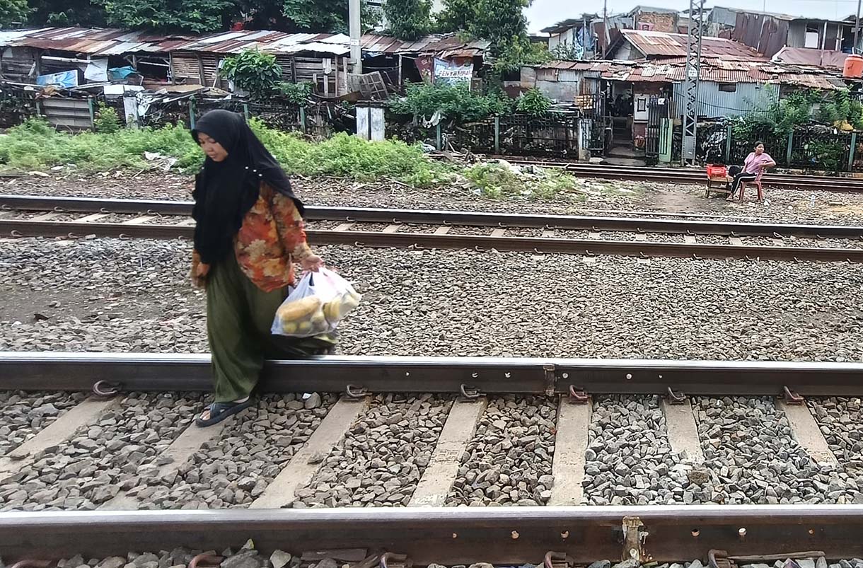 Pemprov DKI Jakarta akan Pasang Pagar Pembatas di Bantaran Rel Warga menyeberang rel kereta api di Kawasan Stasiun Manggarai, Jakarta, Minggu(4/5/2025). (Beritanasional.com/Oke Atmaja)