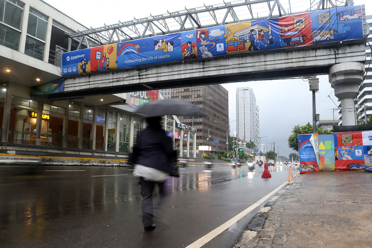 Warga melintas di Kawasan Jalan MJ Thamrin, Jakarta, Senin (12/1/2026). (Beritanasional.com/Oke Atmaja)