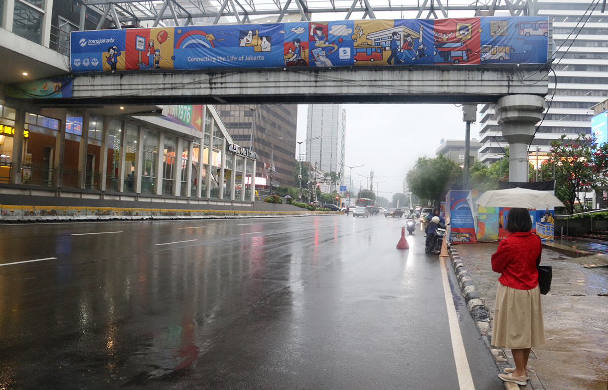Warga melintas di Kawasan Jalan MJ Thamrin, Jakarta, Senin (12/1/2026). (Beritanasional.com/Oke Atmaja)