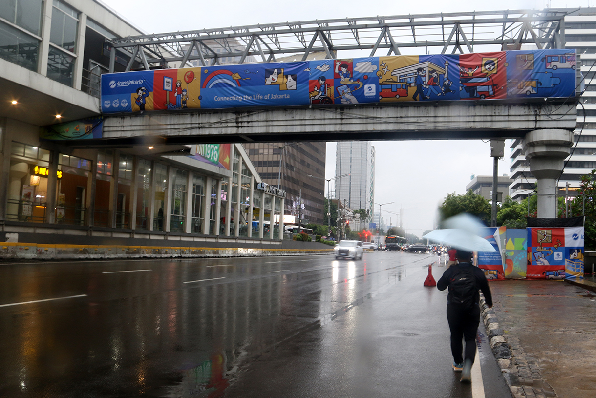 Warga melintas di Kawasan Jalan MJ Thamrin, Jakarta, Senin (12/1/2026). (Beritanasional.com/Oke Atmaja)