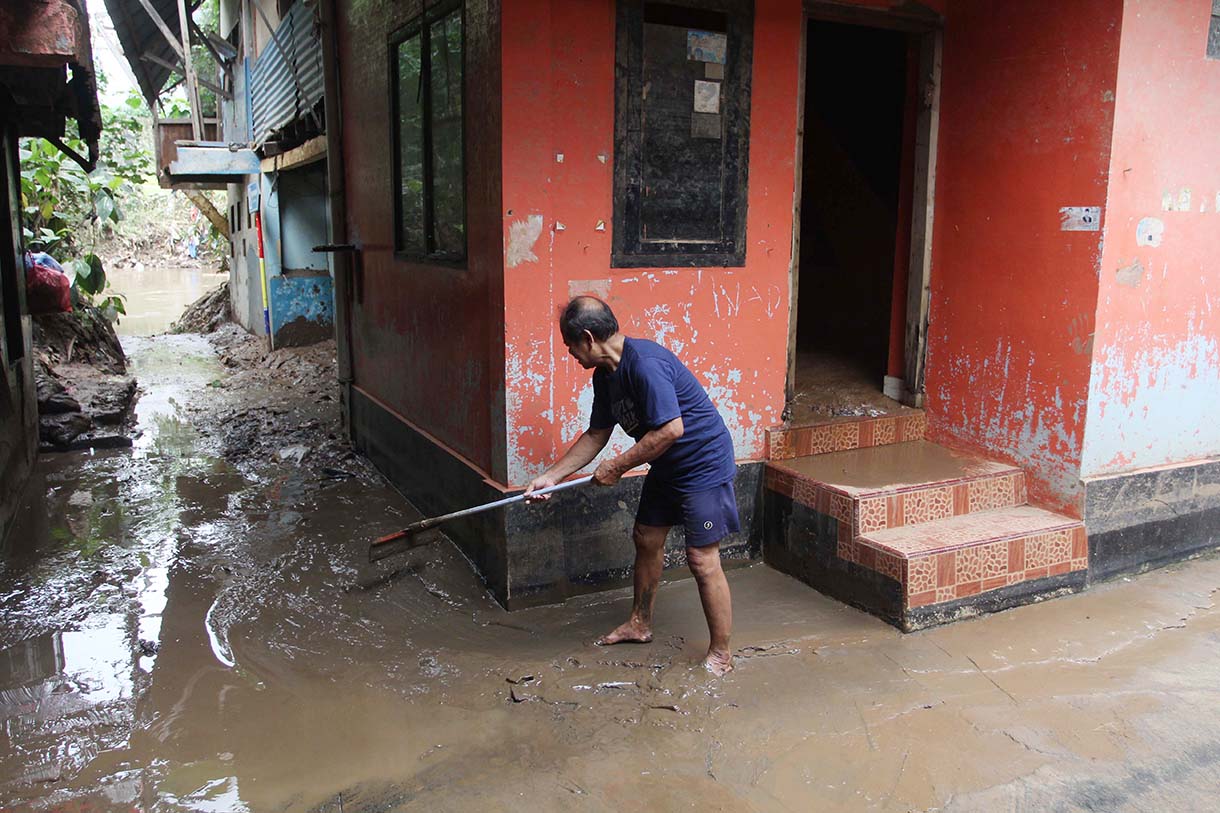 Warga melintas didekat bangunan rumah yang tertempel stiker tanda pembebasan lahan di Cawang, Jakarta, Senin (3/2/2026).(Beritanasional.com/Oke Atmaja)