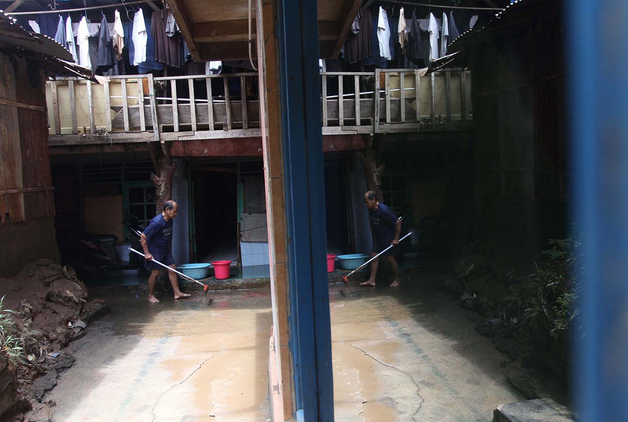 Warga melintas didekat bangunan rumah yang tertempel stiker tanda pembebasan lahan di Cawang, Jakarta, Senin (3/2/2026).(Beritanasional.com/Oke Atmaja)