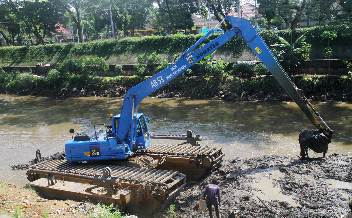 Petugas Dinas Sumber Daya Air Provinsi DKI Jakarta mengoperasikan eskavator untuk mengeruk sedimen lumpur yang mengendap di Kali Ciliwung, Jakarta, Rabu (6/8/2025).  (Beritanasional.com/Oke Atmaja)