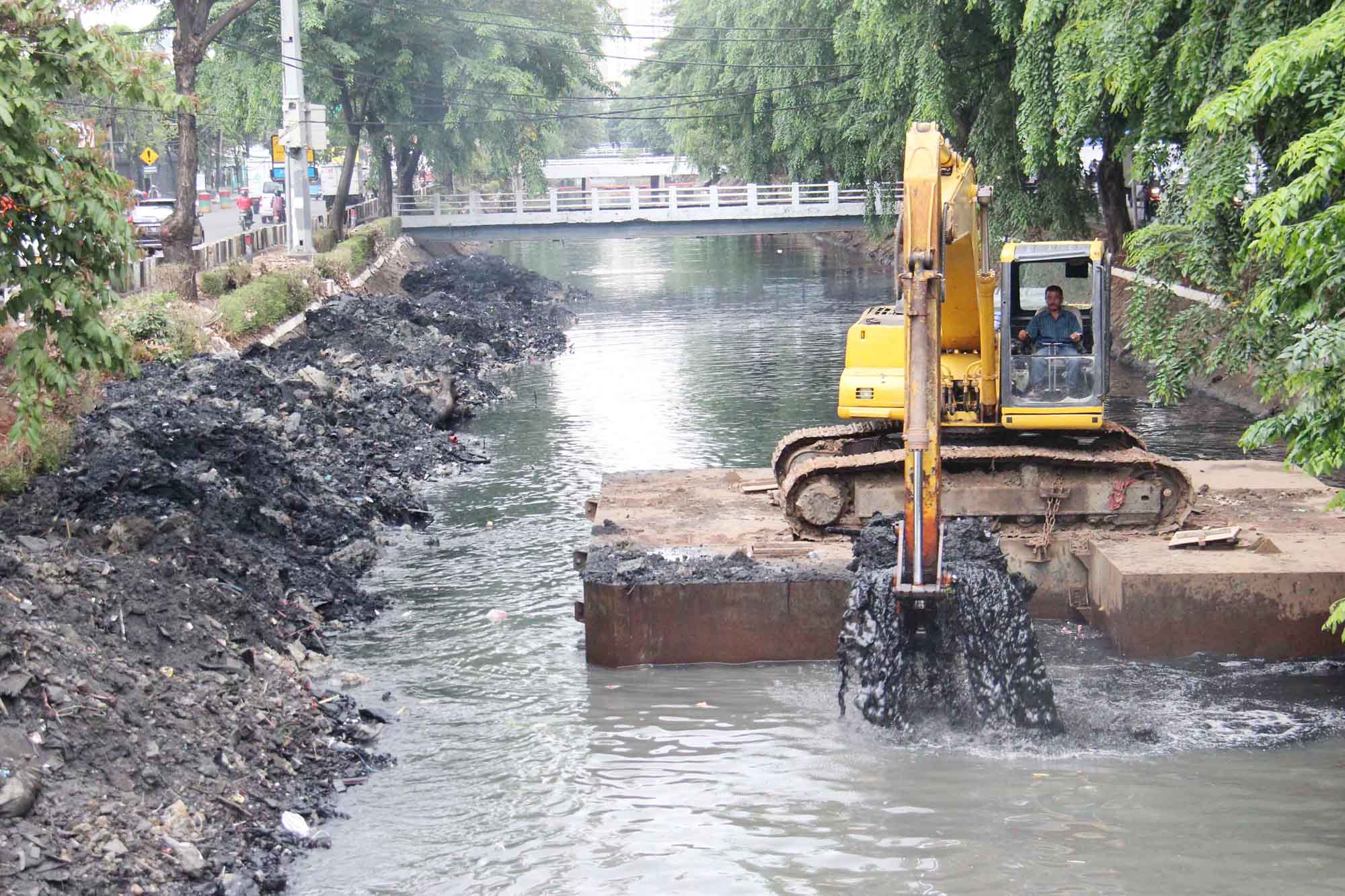 Alat berat ekskavator saat mengeruk lumpur di kali Sunter, Jakarta, Senin (4/11/2024).  (BeritaNasional.com/Oke Atmaja)