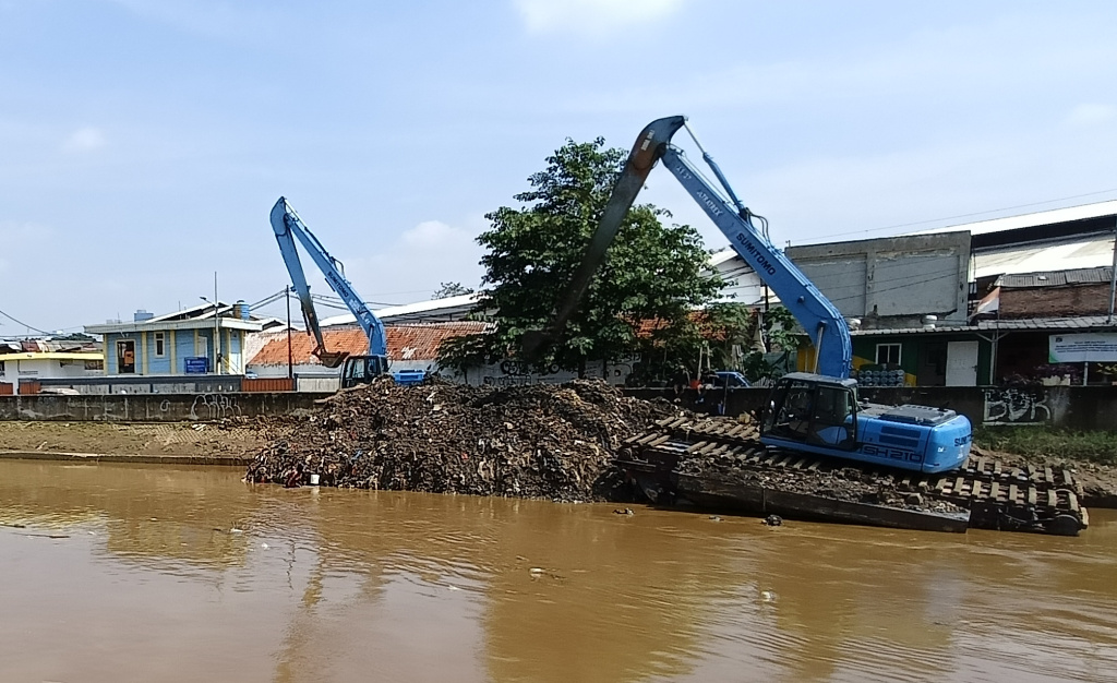 Pemprov Jaktim Gencarkan Pengerukan Kali untuk Atasi Banjir Petugas Dinas Sumber Daya Air mengoperasikan alat berat untuk mengeruk endapan lumpur di Kali Ciliwung, Kampung Melayu, Jakarta Timur, Selasa (8/7/2025). (Beritanasional.com/Oke Atmaja)