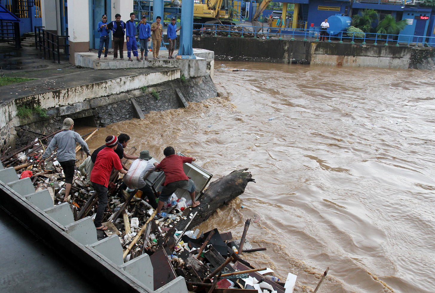 Pemulung mencari sampah plastik untuk dijual kembali di pintu air Manggarai, Jakarta,Selasa (2/7/2024).(BeritaNasional.com/Oke Atmaja)