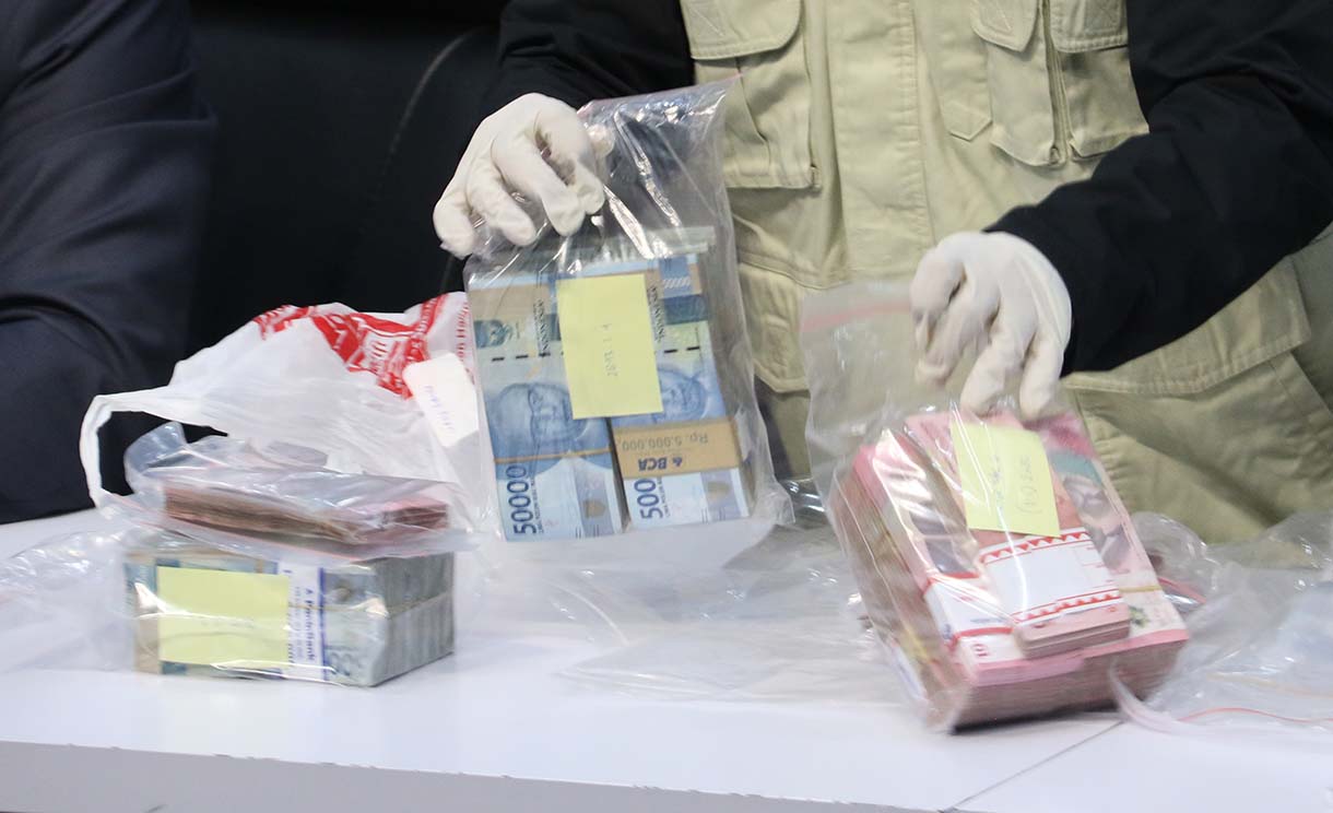 Dua petugas yang menunjukkan barang bukti uang dan logam mulia dari kasus dugaan suap Pemerintah Kabupaten Lampung Tengah. (Beritanasional/Oke Atmaja)