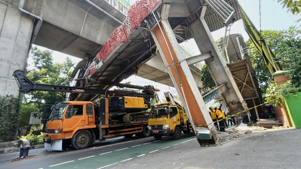 Petugas mengamankan lokasi Jembatan Penyeberangan Orang (JPO) di Jalan Kapten Tendean, Jakarta Selatan, Selasa (14/7/2026). (Beritanasional.com/Oke Atmaja)