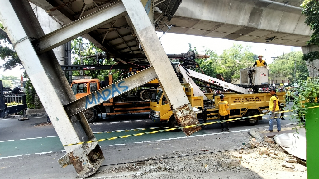 Petugas mengamankan lokasi Jembatan Penyeberangan Orang (JPO) di Jalan Kapten Tendean, Jakarta Selatan, Selasa (14/7/2026). (Beritanasional.com/Oke Atmaja)