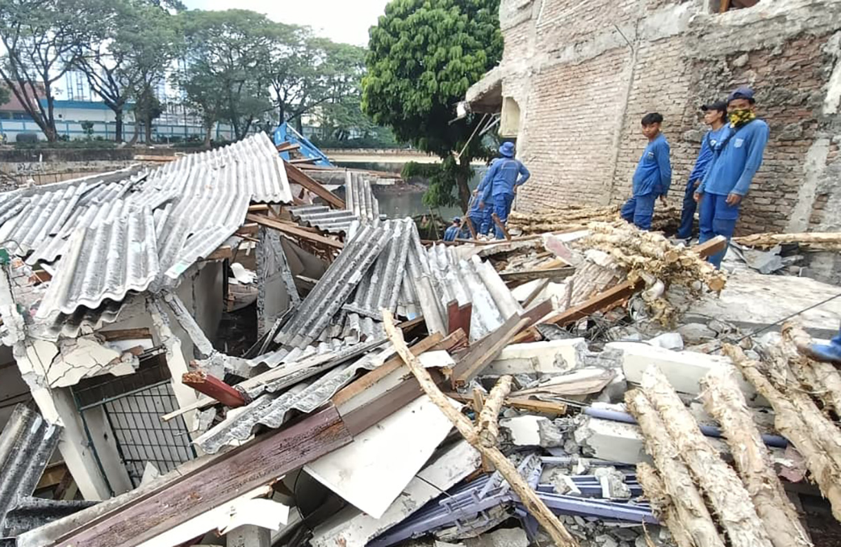 Petugas  Sumber Daya Air( SDA)  Jakarta Pusat  membereskan rerutuhan akibat tanah lonsor di area, Dipo Sampah Pasar Pintu Air, Jalan Petamburan, Tanah Abang, Jakarta, Sabtu (27/6/2026).   (Beritanasional.com/Oke Atmaja)