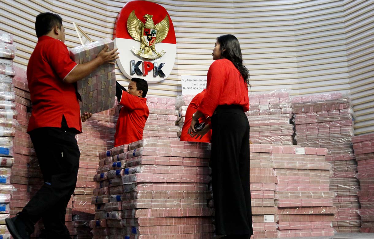 Petugas memindakan uang yang merupakan barang rampasan negara saat acara penyerahan barang rampasan negara dari KPK kepada PT TASPEN di Gedung Merah Putih KPK, Jakarta, Kamis (20/11/2025).  (Beritanasional.com/Oke Atmaja)