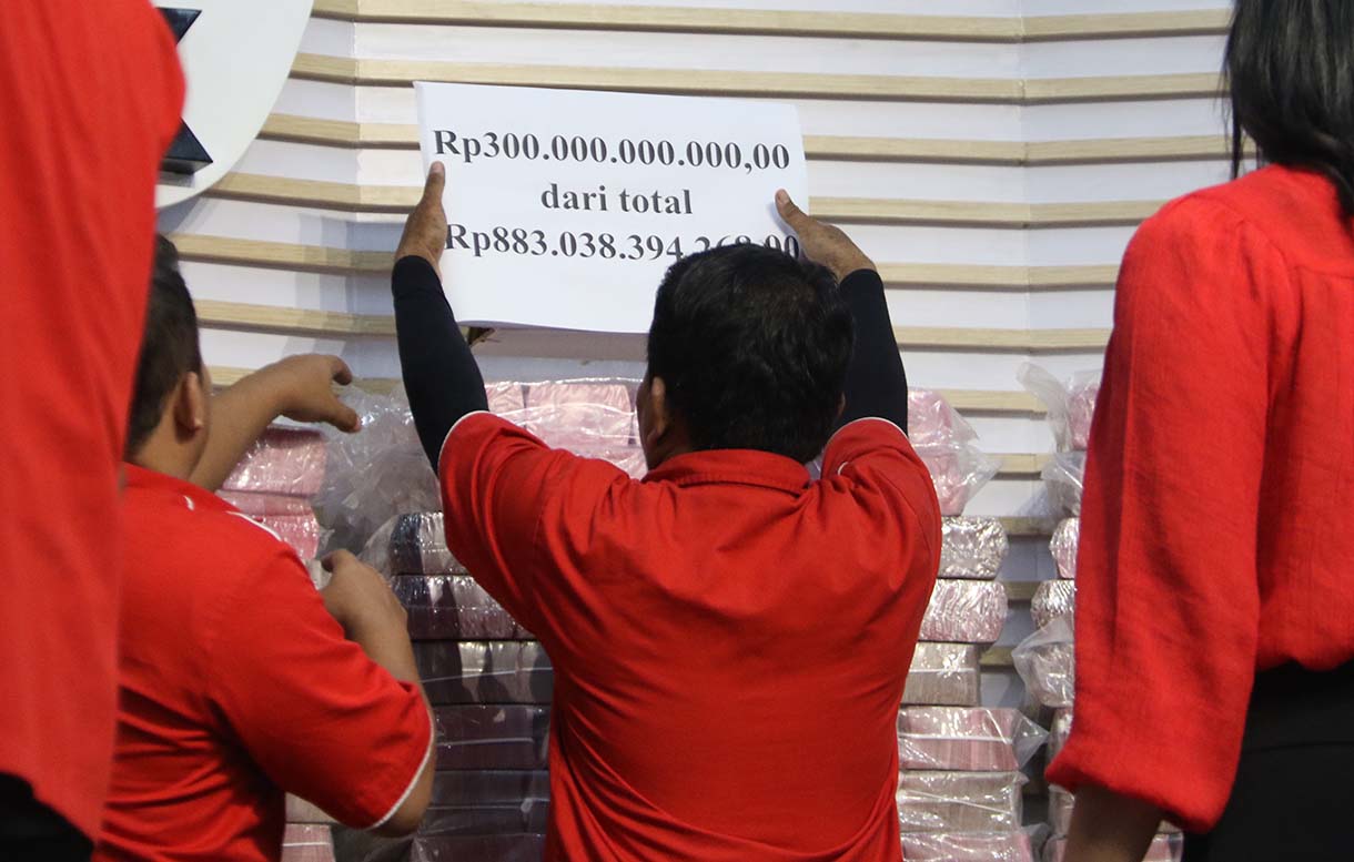 Petugas memindakan uang yang merupakan barang rampasan negara. (Beritanasional.com/Oke Atmaja)