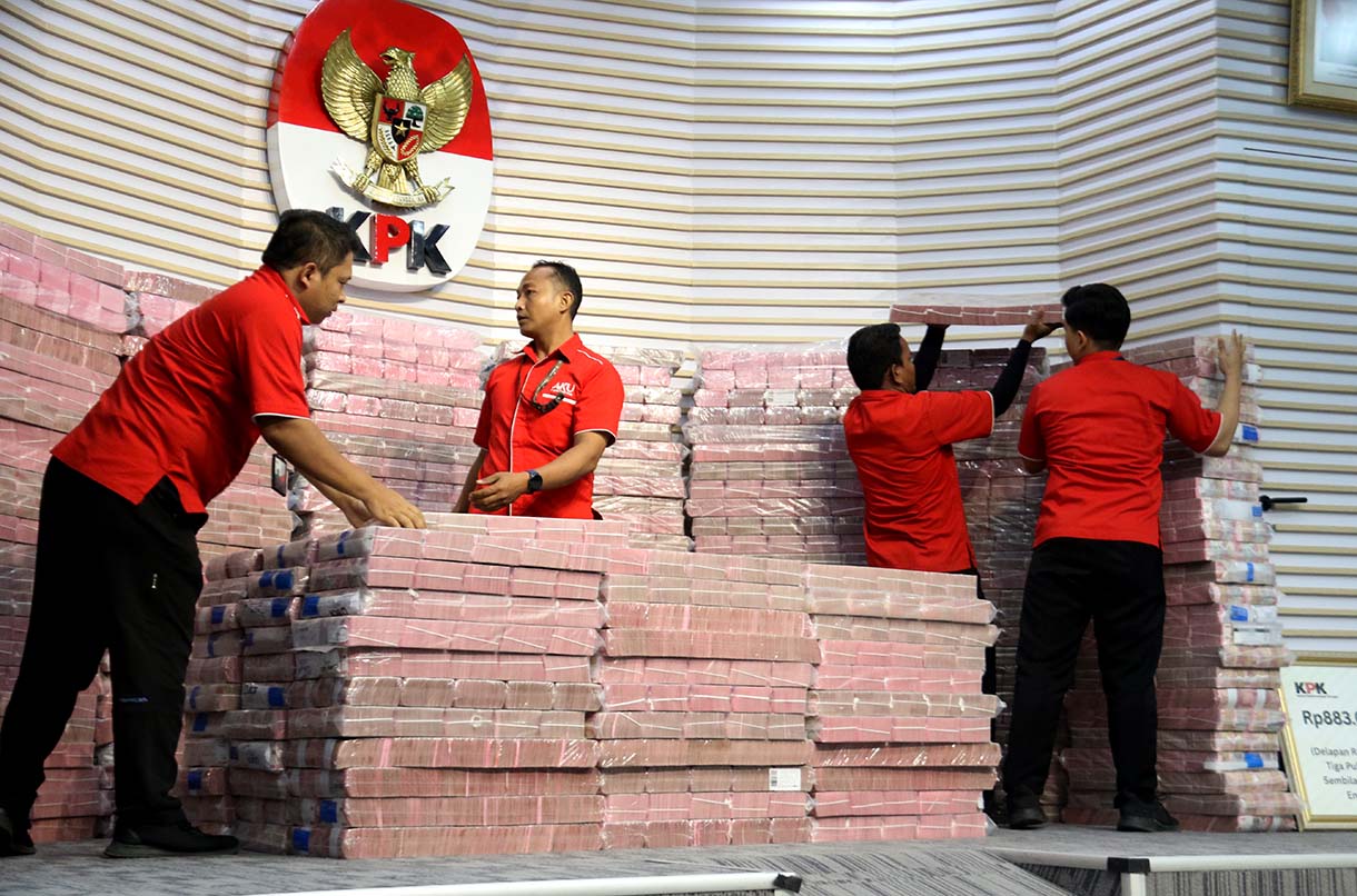Petugas memindakan uang yang merupakan barang rampasan negara saat acara penyerahan barang rampasan negara dari KPK kepada PT TASPEN di Gedung Merah Putih KPK, Jakarta, Kamis (20/11/2025).  (Beritanasional.com/Oke Atmaja)