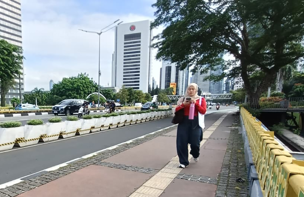 Warga melintas di jembatan Dukuh Atas, Jakarta, Selasa (25/11/2025).(Beritanasional.com/Oke Atmaja)