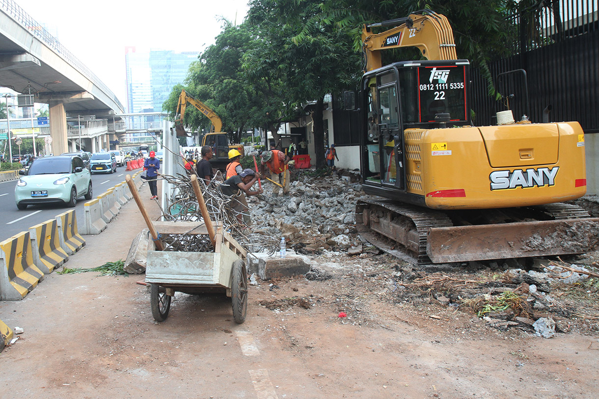 Pekerja menyelesaikan perbaikan trotoar di Jalan H.R. Rasuna Said, Jakarta, Selasa (23/7/2024). (BeritaNasional.com/Oke Atmaja)