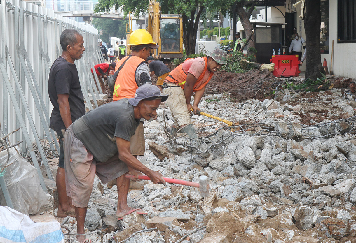 Pekerja menyelesaikan perbaikan trotoar di Jalan H.R. Rasuna Said, Jakarta, Selasa (23/7/2024). (BeritaNasional.com/Oke Atmaja)