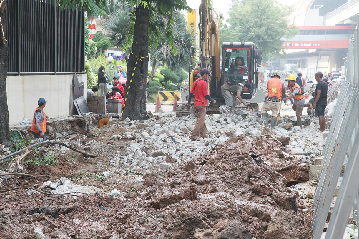 Pekerja menyelesaikan perbaikan trotoar di Jalan H.R. Rasuna Said, Jakarta, Selasa (23/7/2024). (BeritaNasional.com/Oke Atmaja)