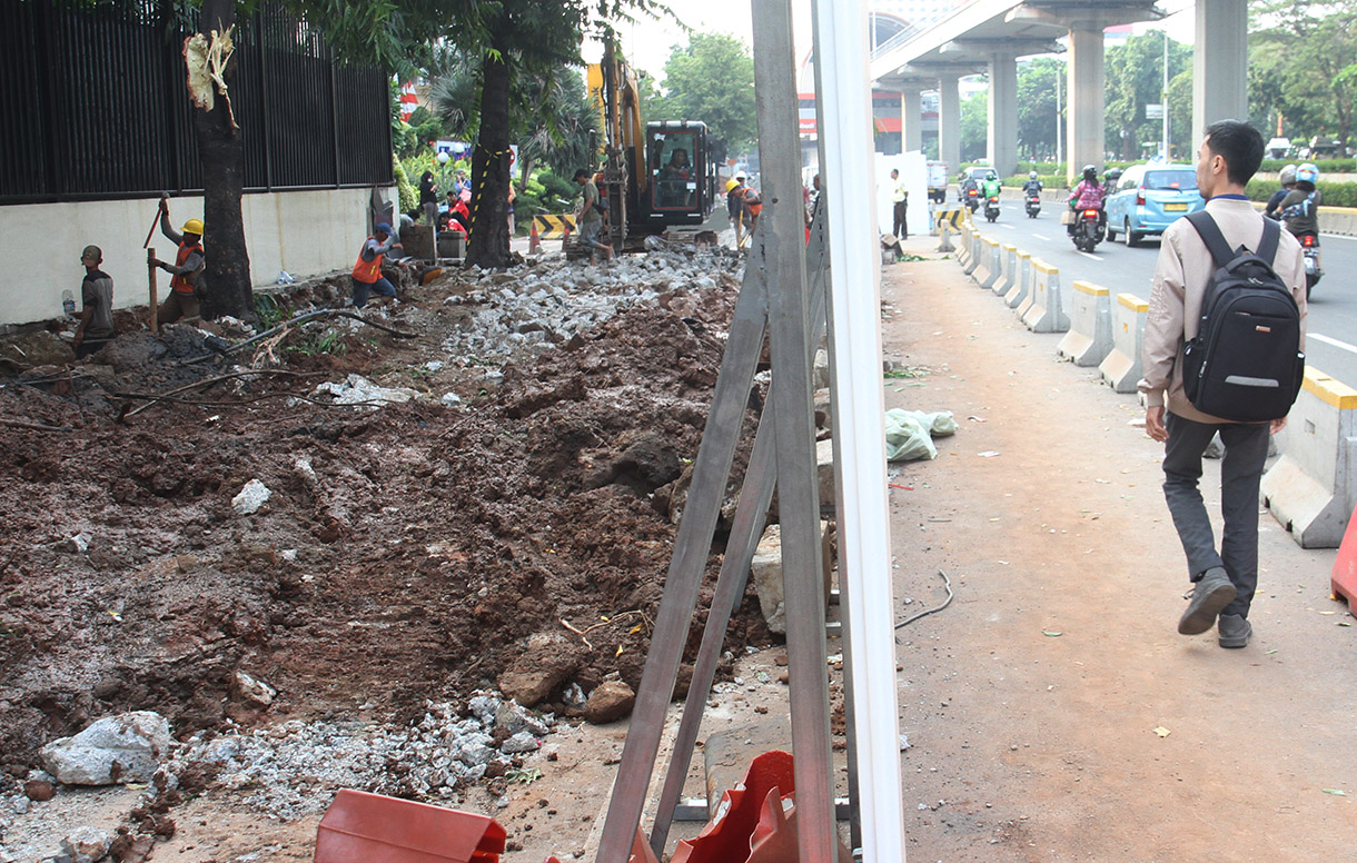 Pekerja menyelesaikan perbaikan trotoar di Jalan H.R. Rasuna Said, Jakarta, Selasa (23/7/2024). (BeritaNasional.com/Oke Atmaja)