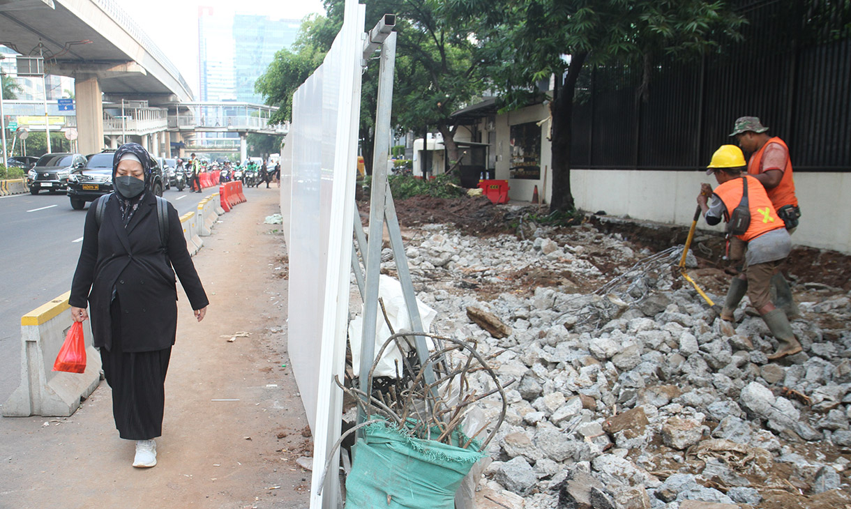 Pekerja menyelesaikan perbaikan trotoar di Jalan H.R. Rasuna Said, Jakarta, Selasa (23/7/2024). (BeritaNasional.com/Oke Atmaja)