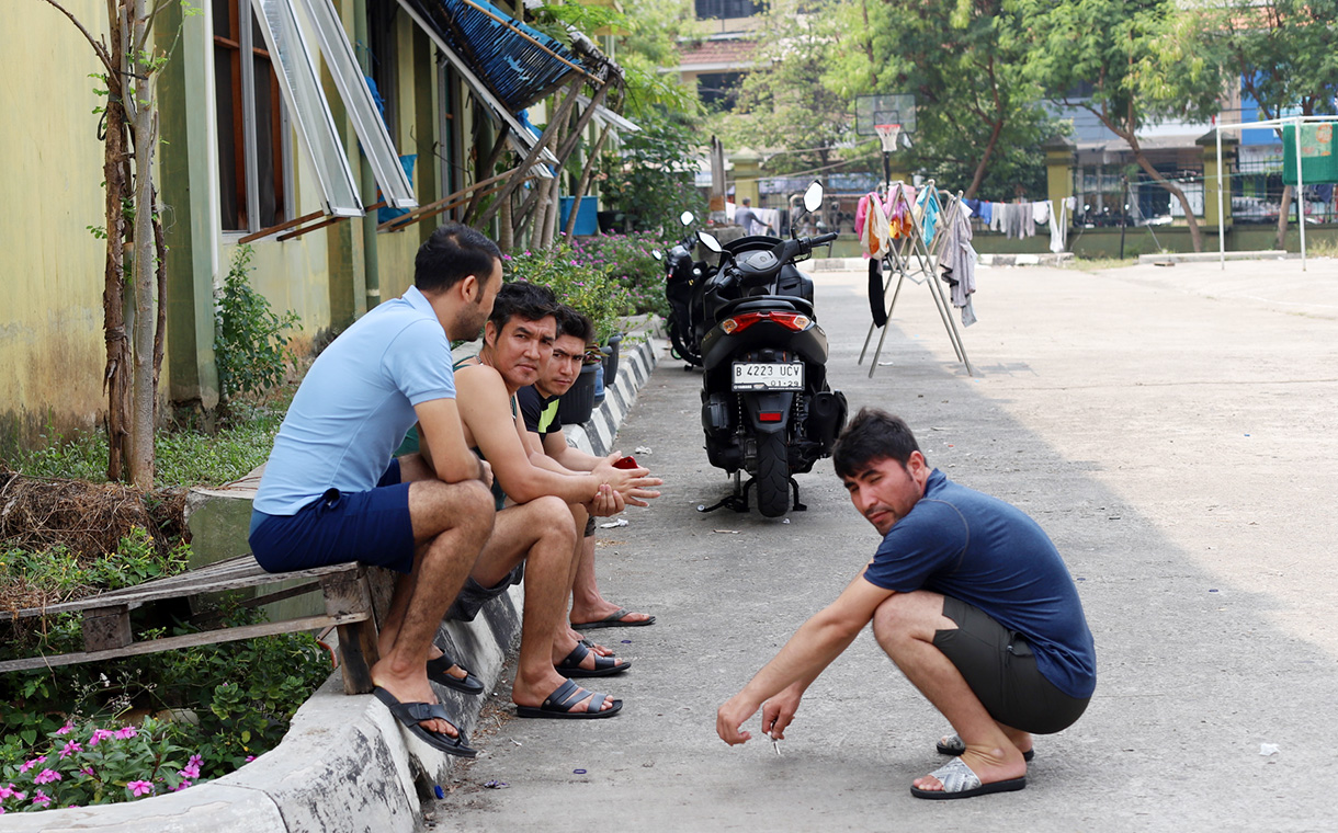 Sejumlah pencari suaka duduk di depan tempat penampungan sementara di Kalideres, Jakarta Barat, Kamis (15/8/2024). (BeritaNasional.com/ Oke Atmaja)