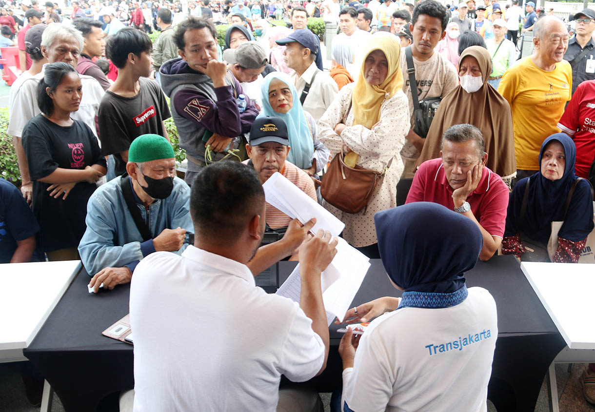 Sejumlah warga lanjut usia (lansia) antre untuk mendaftar dan perpanjangan program Kartu Layanan Gratis (KLG) pada Hari Bebas Kendaraan Bermotor (HBKB) di kawasan Bundaran HI, Jakarta Pusat, Minggu (16/11/2025).  (Beritanasional.com/Oke Atmaja)