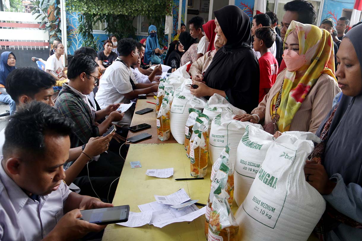 Petugas memberikan beras saat pendistribusian bantuan pangan berupa beras dan minyak goreng, di Balai RW 03 Menteng, Jakarta, Rabu (10/6/2026).  (Beritanasional.com/Oke Atmaja)