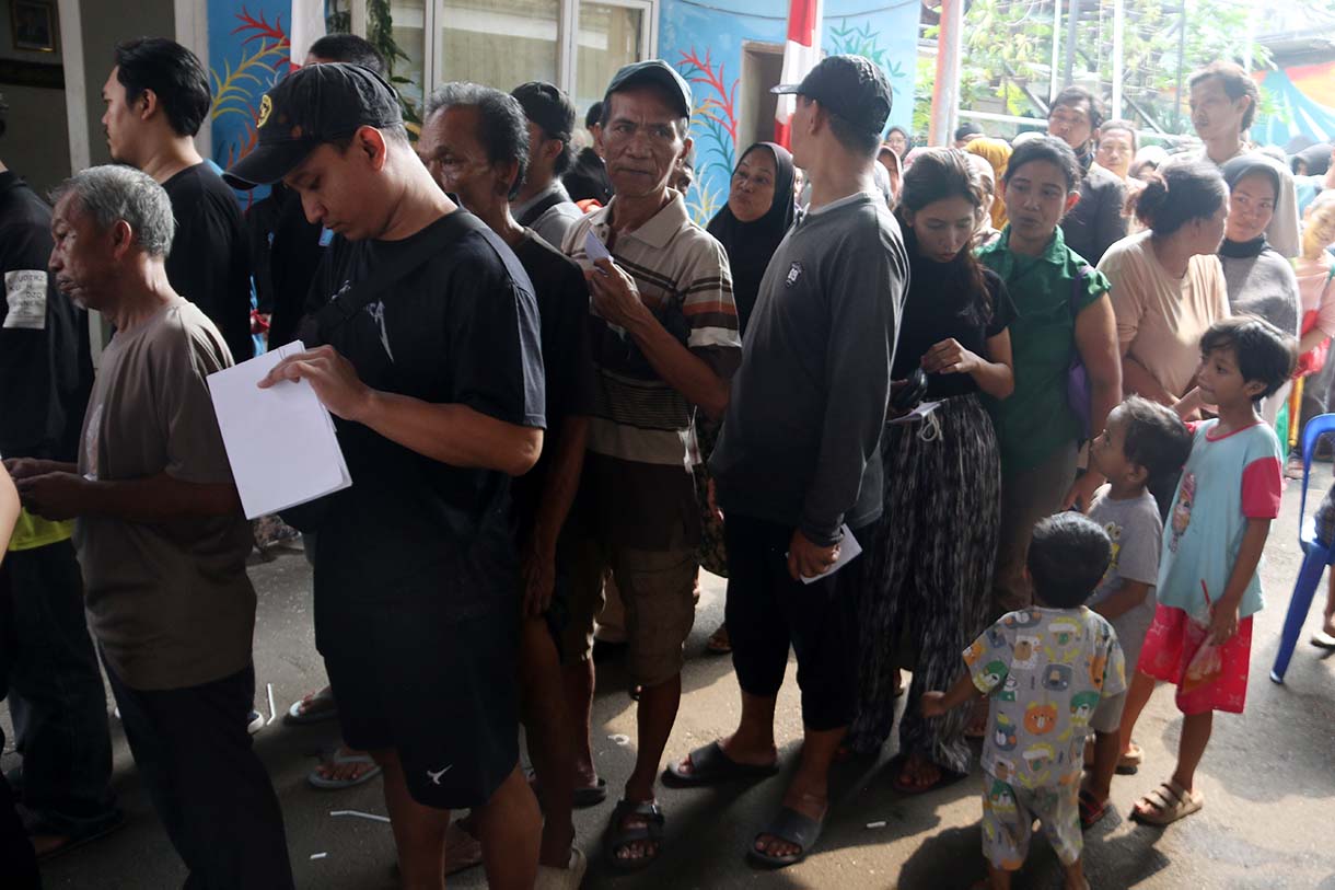 Petugas memberikan beras saat pendistribusian bantuan pangan berupa beras dan minyak goreng, di Balai RW 03 Menteng, Jakarta, Rabu (10/6/2026).  (Beritanasional.com/Oke Atmaja)