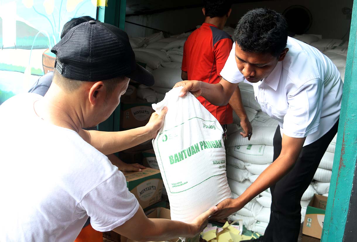 Petugas memberikan beras saat pendistribusian bantuan pangan berupa beras dan minyak goreng, di Balai RW 03 Menteng, Jakarta, Rabu (10/6/2026).  (Beritanasional.com/Oke Atmaja)