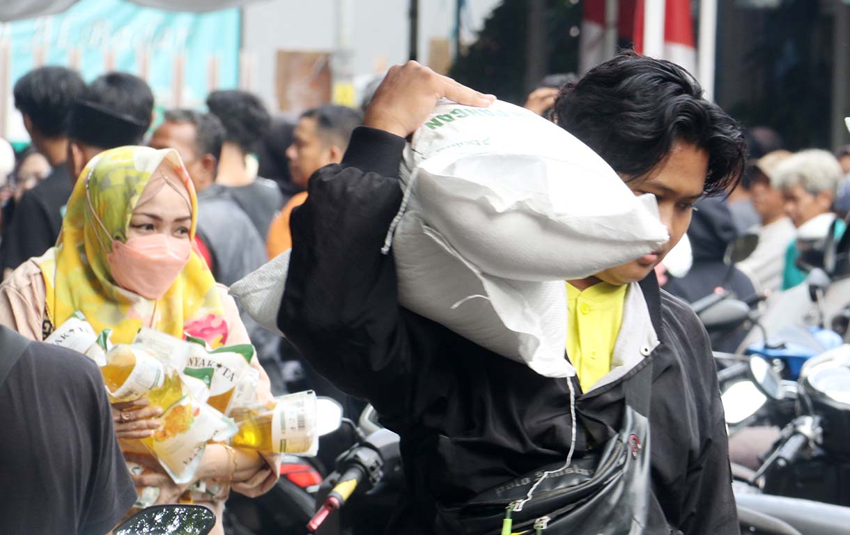 Petugas memberikan beras saat pendistribusian bantuan pangan berupa beras dan minyak goreng, di Balai RW 03 Menteng, Jakarta, Rabu (10/6/2026).  (Beritanasional.com/Oke Atmaja)