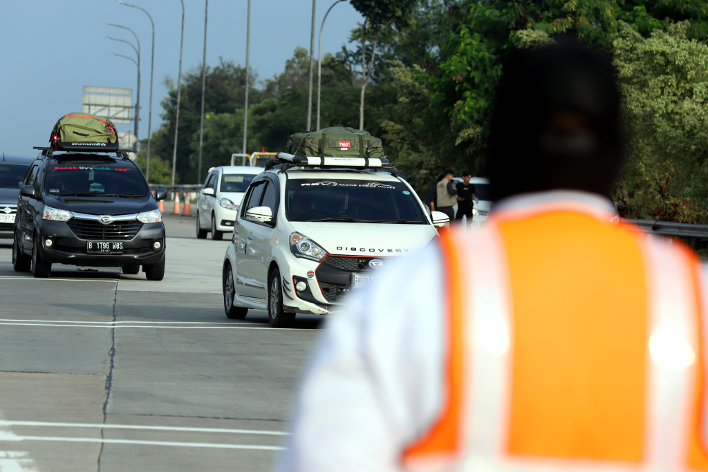 Petugas memberi arah kepada pemudik yang melintas di Tol Cikampek. (BeritaNasional/Elvis Sendouw)