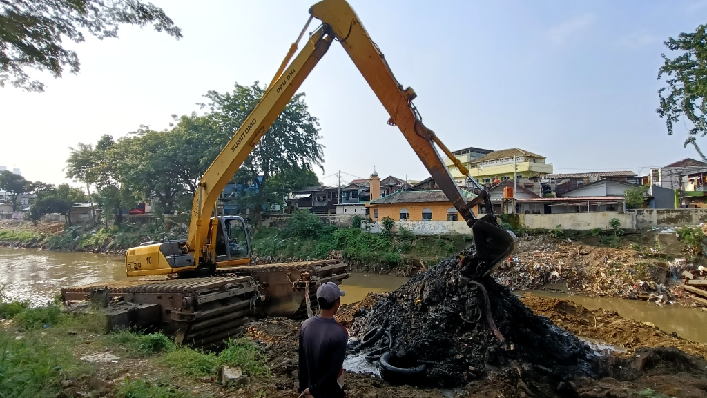 Pengerukan Endapan Lumpur di Kali Ciliwung Petugas Suku Dinas Sumber Daya Air (SDA) Jakarta Barat mengoperasikan alat berat untuk mengangkat lumpur di Kali Ciliwung ,Jakarta, Minggu (11/5/2025). (Berita nasional.com/ Oke Atmaja)