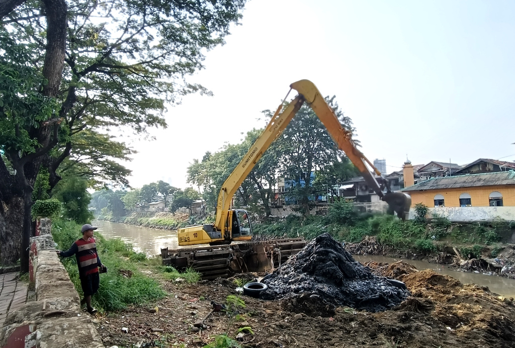 Pengerukan Endapan Lumpur di Kali Ciliwung Petugas Suku Dinas Sumber Daya Air (SDA) Jakarta Barat mengoperasikan alat berat untuk mengangkat lumpur di Kali Ciliwung ,Jakarta, Minggu (11/5/2025). (Berita nasional.com/ Oke Atmaja)