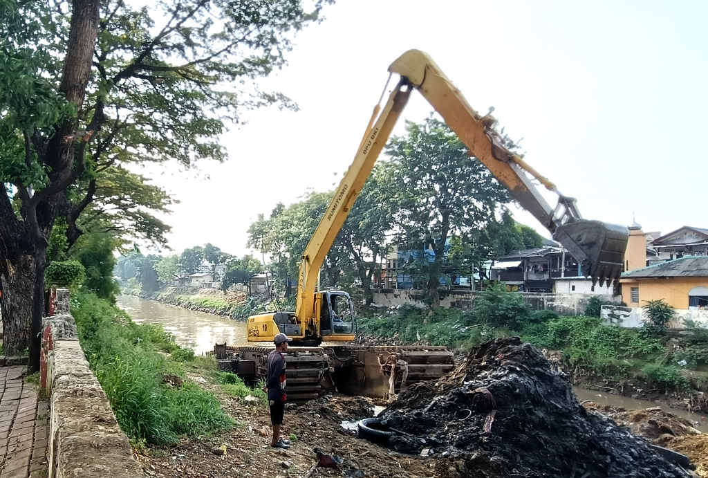 Pengerukan Endapan Lumpur di Kali Ciliwung Petugas Suku Dinas Sumber Daya Air (SDA) Jakarta Barat mengoperasikan alat berat untuk mengangkat lumpur di Kali Ciliwung ,Jakarta, Minggu (11/5/2025). (Berita nasional.com/ Oke Atmaja)