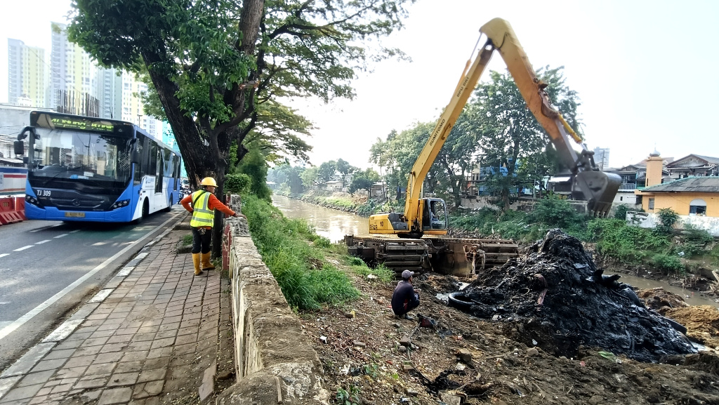 Pengerukan Endapan Lumpur di Kali Ciliwung Petugas Suku Dinas Sumber Daya Air (SDA) Jakarta Barat mengoperasikan alat berat untuk mengangkat lumpur di Kali Ciliwung ,Jakarta, Minggu (11/5/2025). (Berita nasional.com/ Oke Atmaja)