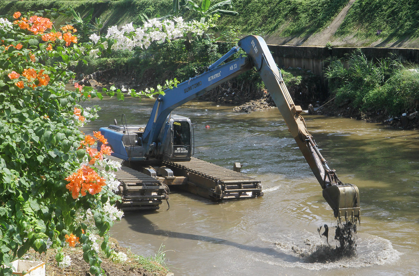 Alat berat mengeruk endapan lumpur di Kali Ciliwung, Jalan Latuharhary, Jakarta, Jumat (7/6/2024). (BeritaNasional.Com/Oke Atmaja)