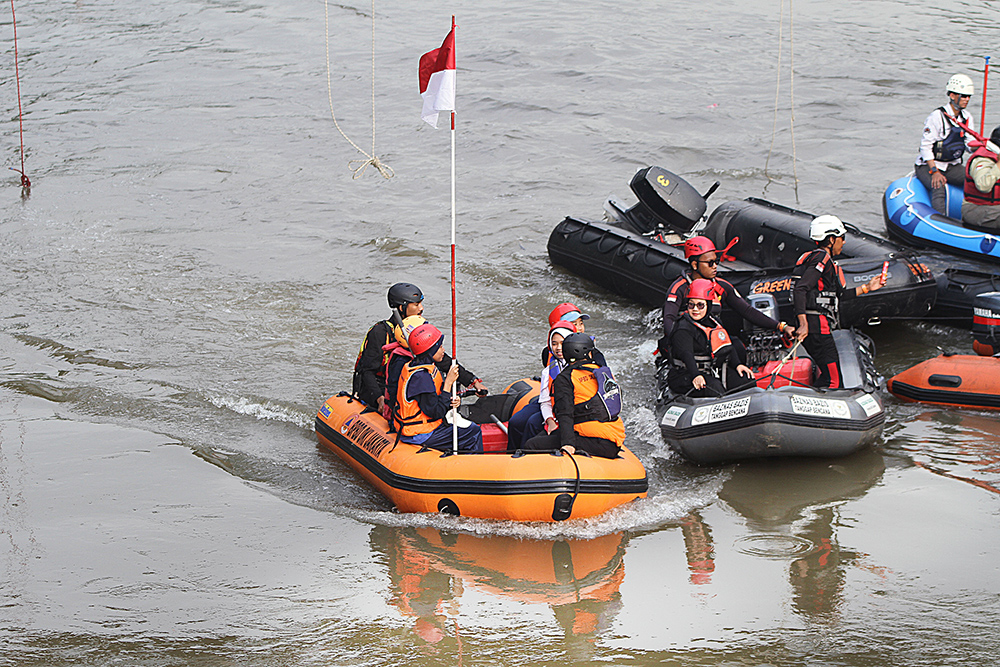 Petugas gabungan mengibarkan Bendera Merah Putih berukuran raksasa di sungai Ciliwung. (BeritaNasional/Elvis Sendouw)