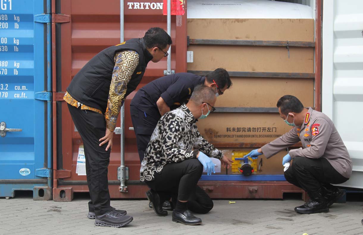 Petugas Bea Cukai menutup pintu kontainer berisi produk turunan minyak sawit mentah atau crude palm oil (CPO) pada konferensi pers penindakan produk yang melanggar aturan ekspor di Jakarta Utara, Kamis (6/11/2025).  (Beritanasional.com/Oke Atmaja)