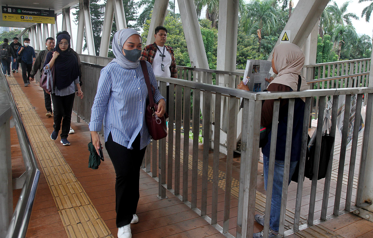 Seorang penjual koran menawarkan daganganya saat berjualan di Jembatan Penyebrangan Orang Halte Transjakarta Jenderal Sudirman, Jakarta, Rabu (08/01/2025).(BeritaNasional.com/Oke Atmaja)