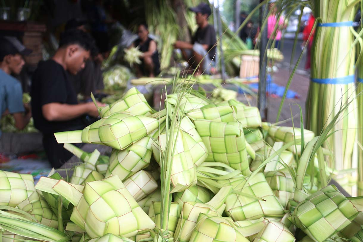 Pedagang menganyam kulit ketupat di Pasar Pondok Labu, Jakarta, Jumat (20/3/2026).(Beritanasional.com/Oke Atmaja)