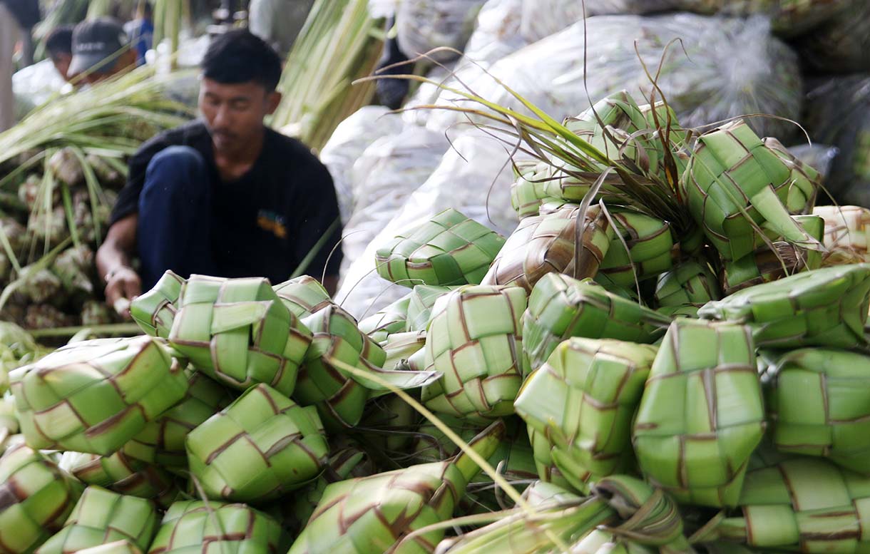Pedagang menganyam kulit ketupat di Pasar Pondok Labu, Jakarta, Jumat (20/3/2026).(Beritanasional.com/Oke Atmaja)