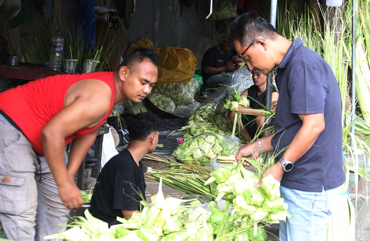 Pedagang menganyam kulit ketupat di Pasar Pondok Labu, Jakarta, Jumat (20/3/2026).(Beritanasional.com/Oke Atmaja)