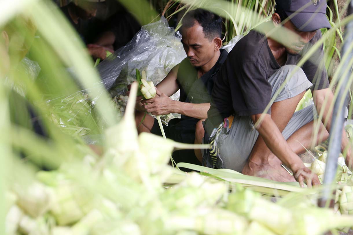 Pedagang menganyam kulit ketupat di Pasar Pondok Labu, Jakarta, Jumat (20/3/2026).(Beritanasional.com/Oke Atmaja)