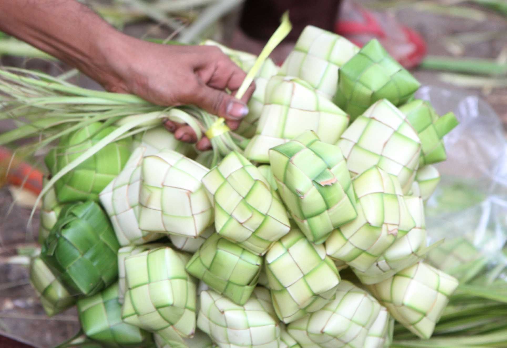 Pedagang membuat bungkus ketupat di Pasar Minggu, Jakarta, Jumat (5/4/2024).  (BeritaNasional.com/Oke Atmaja)