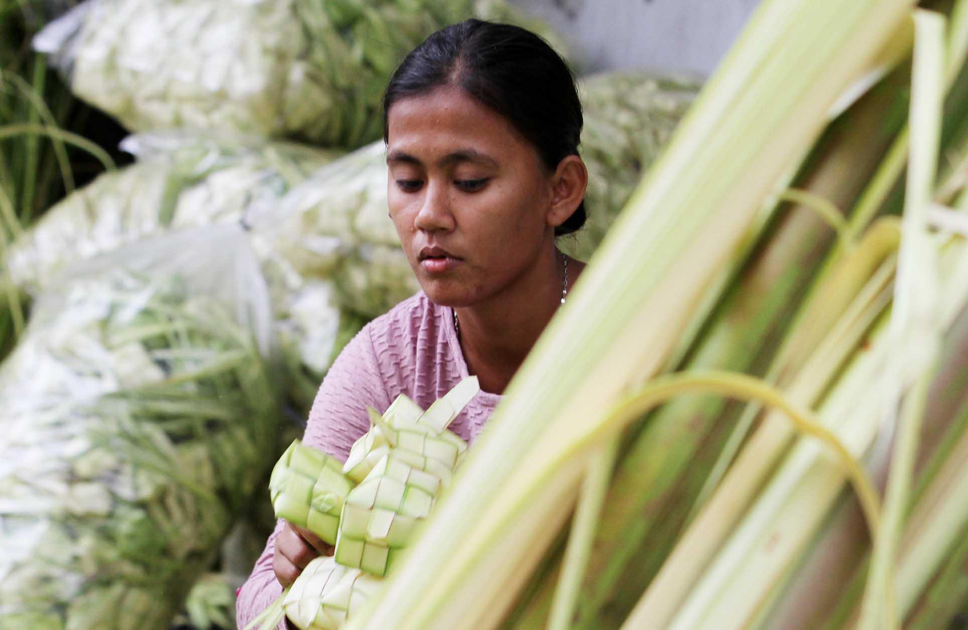 Pedagang membuat bungkus ketupat di Pasar Minggu, Jakarta, Jumat (5/4/2024).  (BeritaNasional.com/Oke Atmaja)