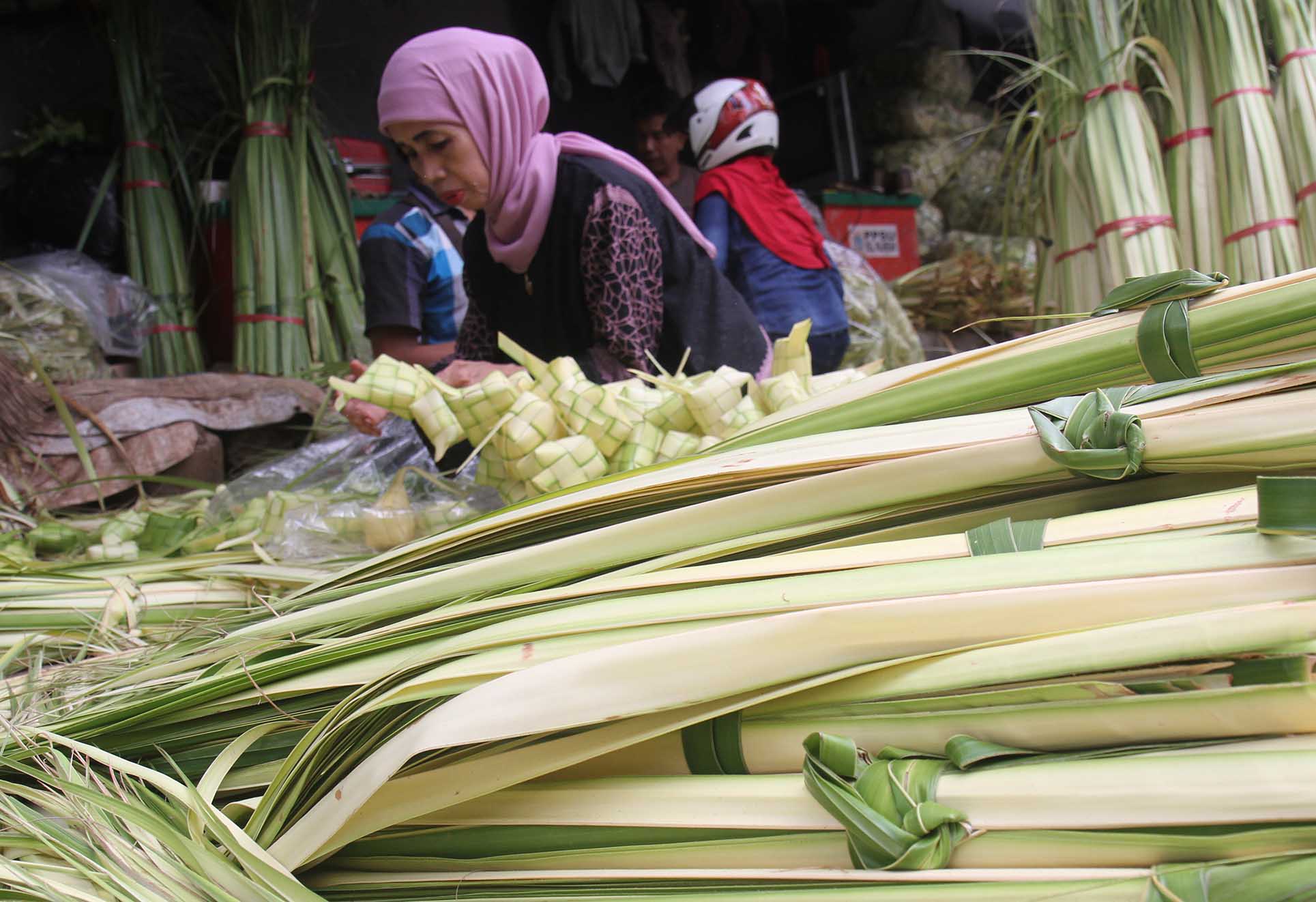 Pedagang membuat bungkus ketupat di Pasar Minggu, Jakarta, Jumat (5/4/2024).  (BeritaNasional.com/Oke Atmaja)