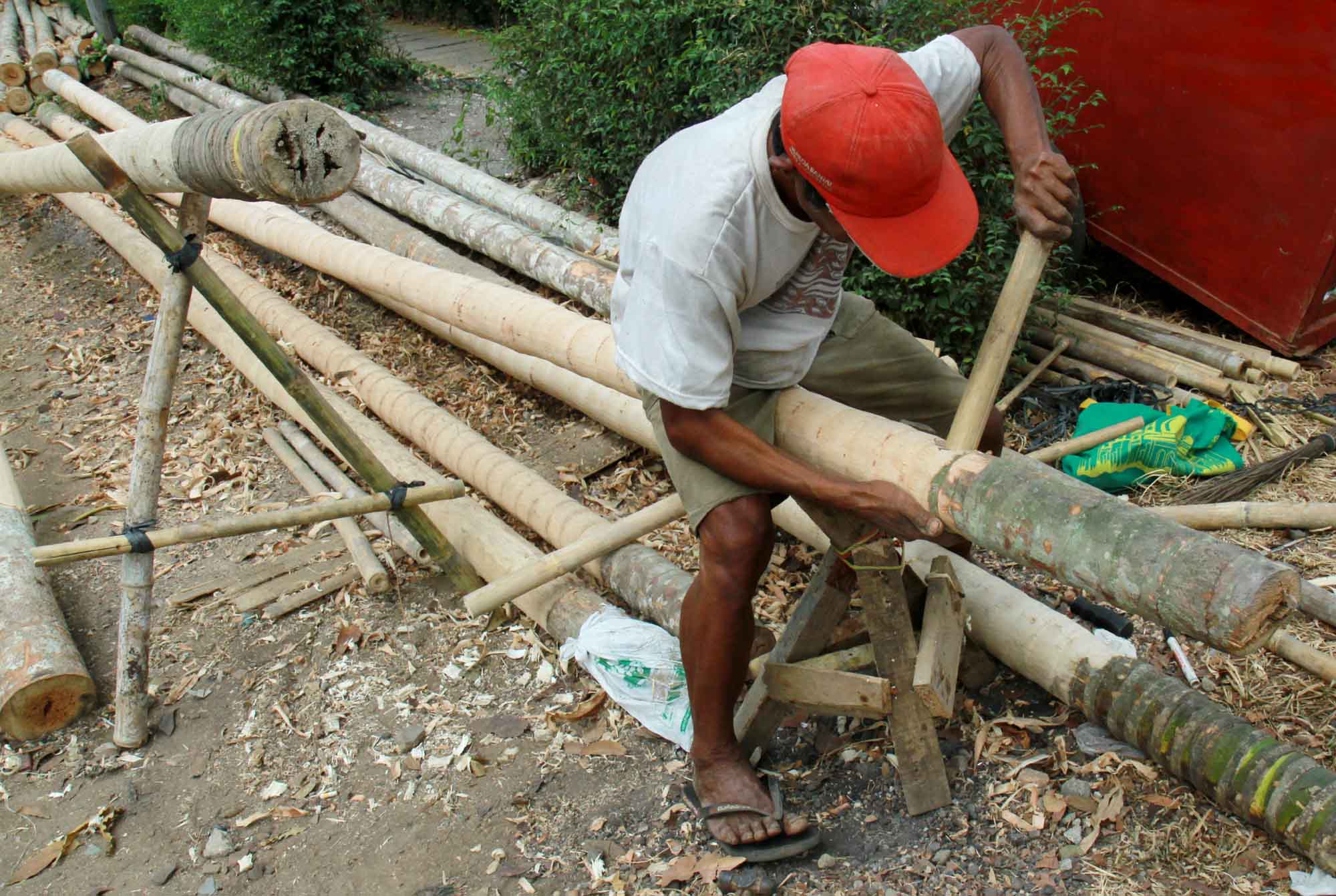 Pekerja mengupas kulit batang pohon pohon pinang di kawasan Manggarai, Jakarta, Sabtu(3/8/2024). (BeritaNasional.com/Oke Atmaja)