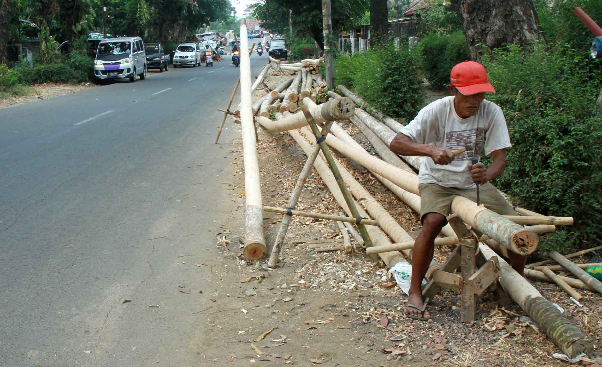 Pekerja mengupas kulit batang pohon pohon pinang di kawasan Manggarai, Jakarta, Sabtu(3/8/2024). (BeritaNasional.com/Oke Atmaja)