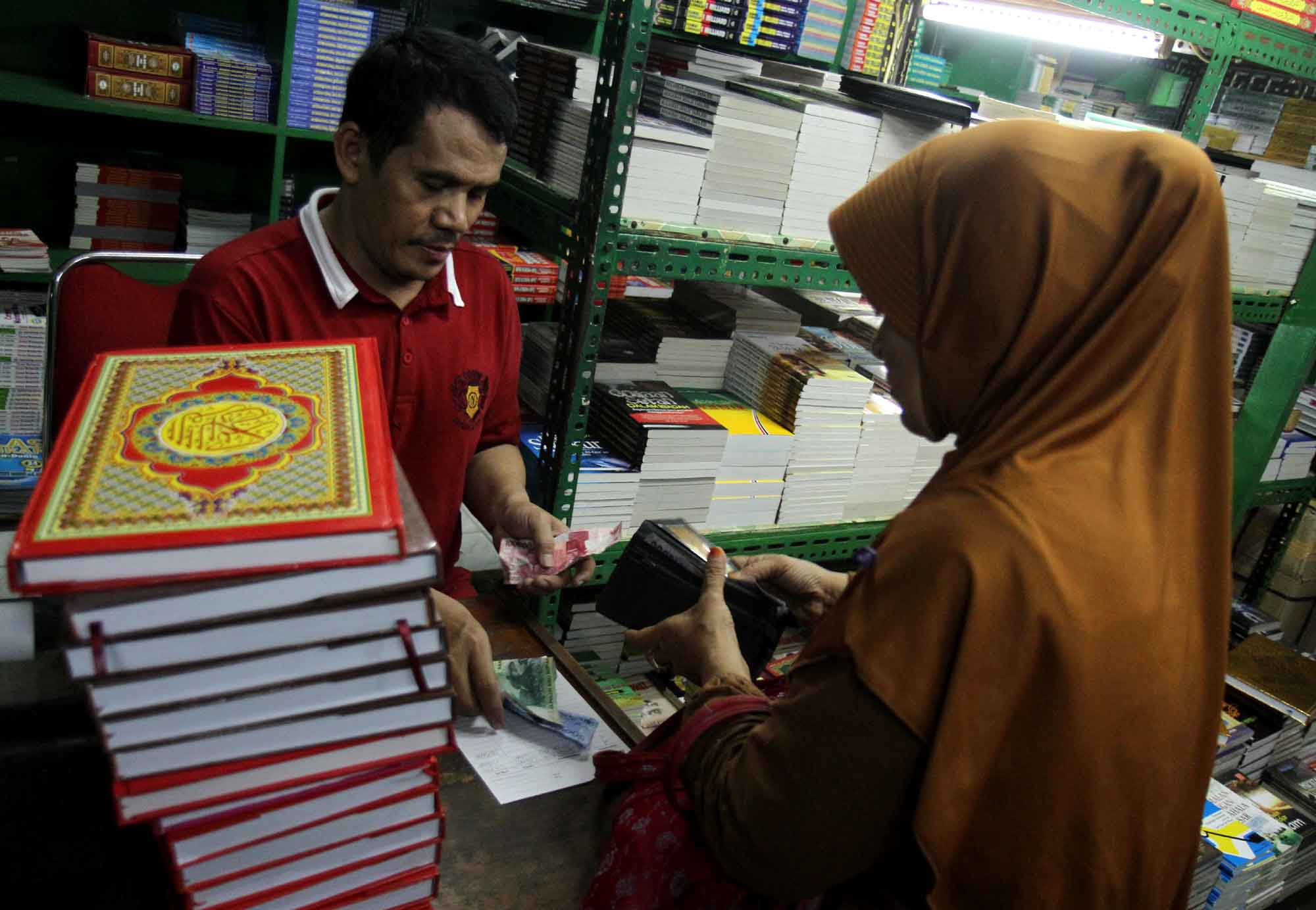 Penjual menata Alquran di tokonya, Kwitang, Senen, Jakarta, Minggu (16/3/2025). (Beritanasional.com/Oke Atmaja)