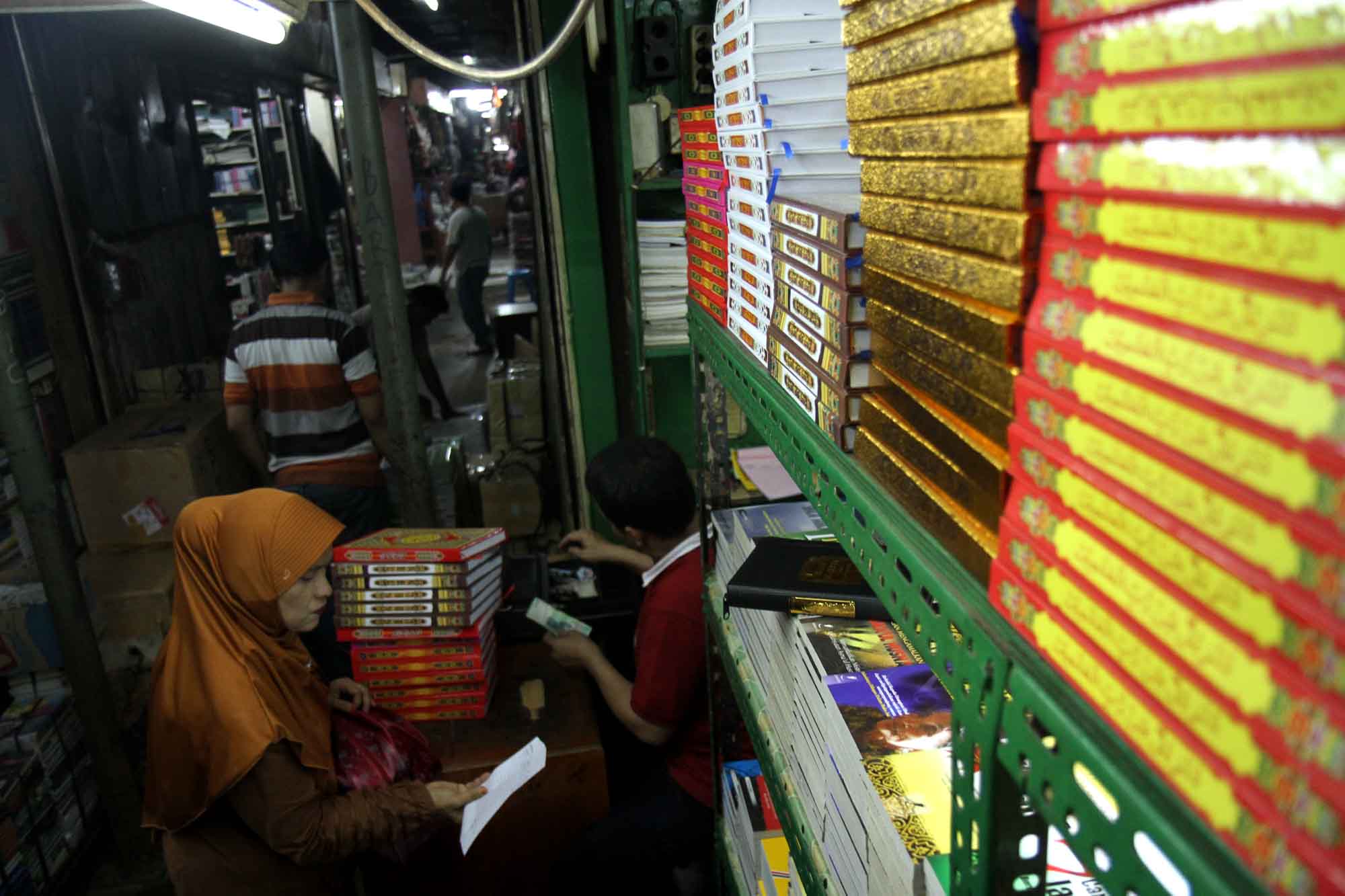 Penjual menata Alquran di tokonya, Kwitang, Senen, Jakarta, Minggu (16/3/2025). (Beritanasional.com/Oke Atmaja)