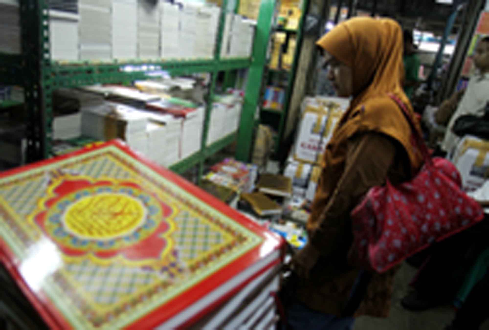 Penjual menata Alquran di tokonya, Kwitang, Senen, Jakarta, Minggu (16/3/2025). (Beritanasional.com/Oke Atmaja)